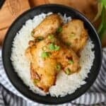 A black bowl of rice topped with Air Fryer Teriyaki Chicken.