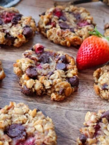 Breakfast cookies on a wood board with fresh fruit.