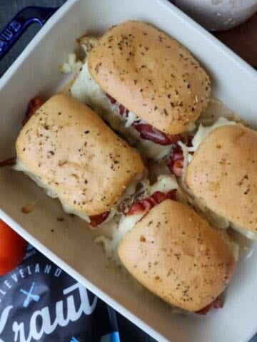 4 Chicken Reuben Sliders in a pan.