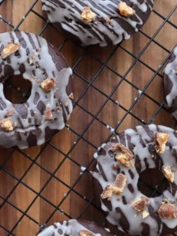 Chocolate donuts with snickers on top.