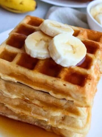 Fluffy gluten free waffles with bananas on the top.