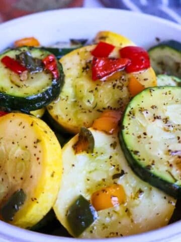 Sautéed zucchini and squash in a white bowl.