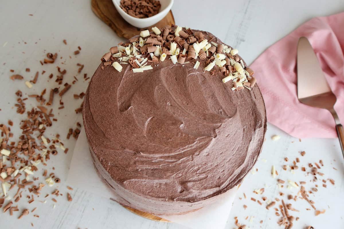 A chocolate frosted cake with chocolate garnish on top.