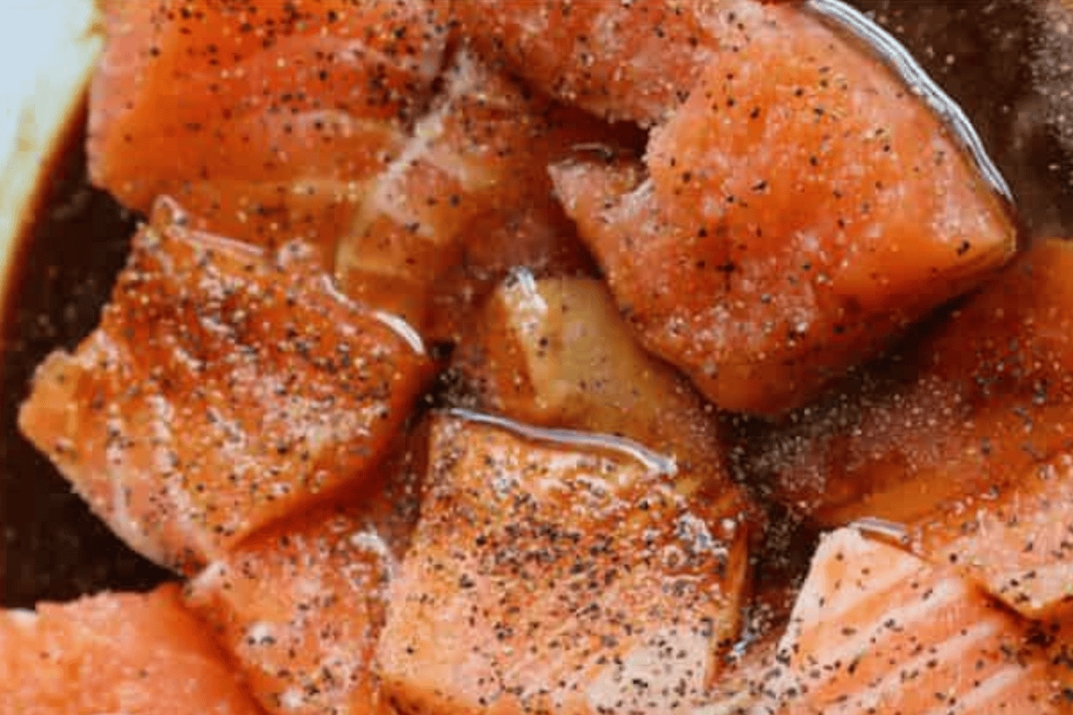 Raw salmon cubbed into 1 inch pieces and put in sauce.