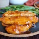Chicken Fillets with green beans on a black plate.
