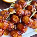 Orange meatballs with lemon on the side.