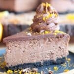 Slice of chocolate orange cheesecake topped with dollop of chocolate frosting.