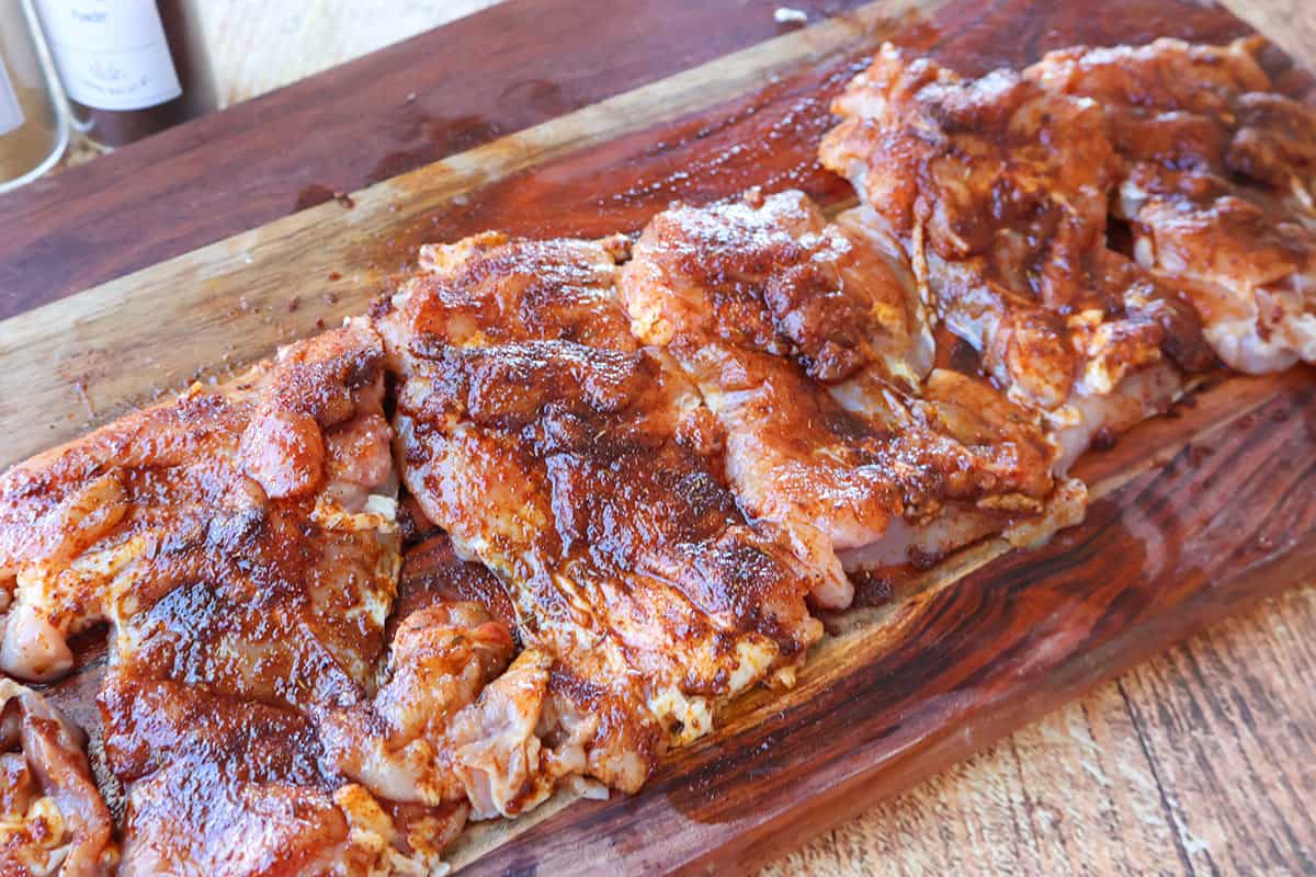 Six boneless skinless chicken thighs coated with a seasoning rub.