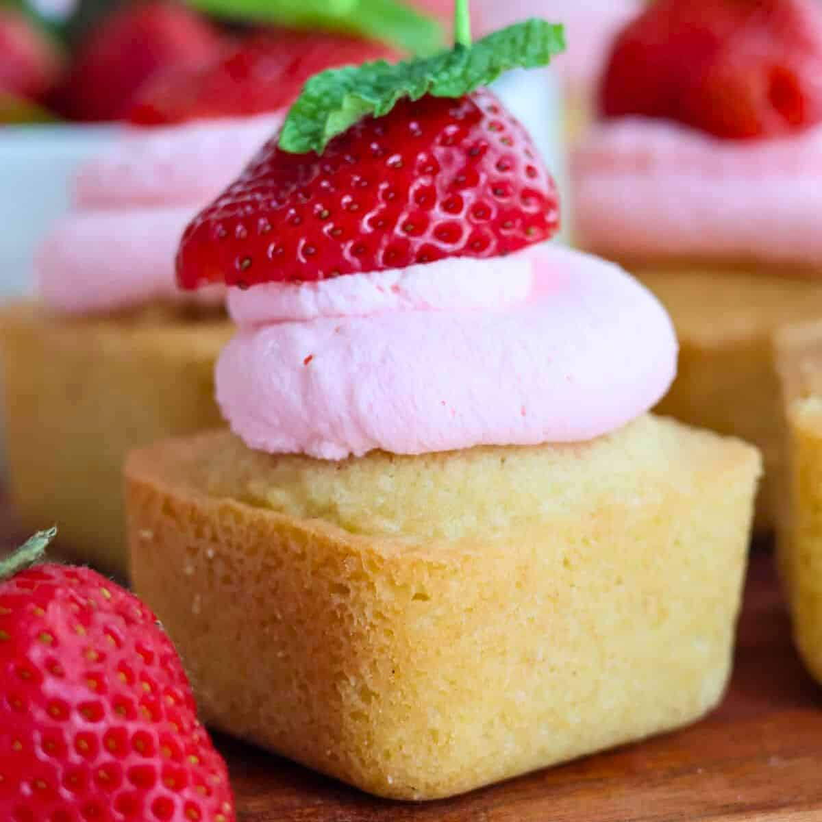 Gluten-free strawberry shortcake bite with whipped cream and strawberry.