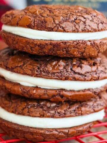 Three chocolate sandwich cookies stacked atop one another.