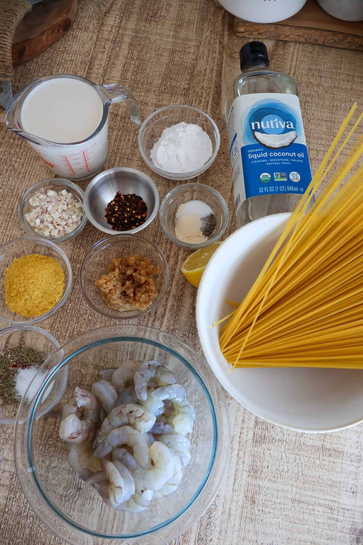 Individual shrimp pasta ingredients in bowls on table