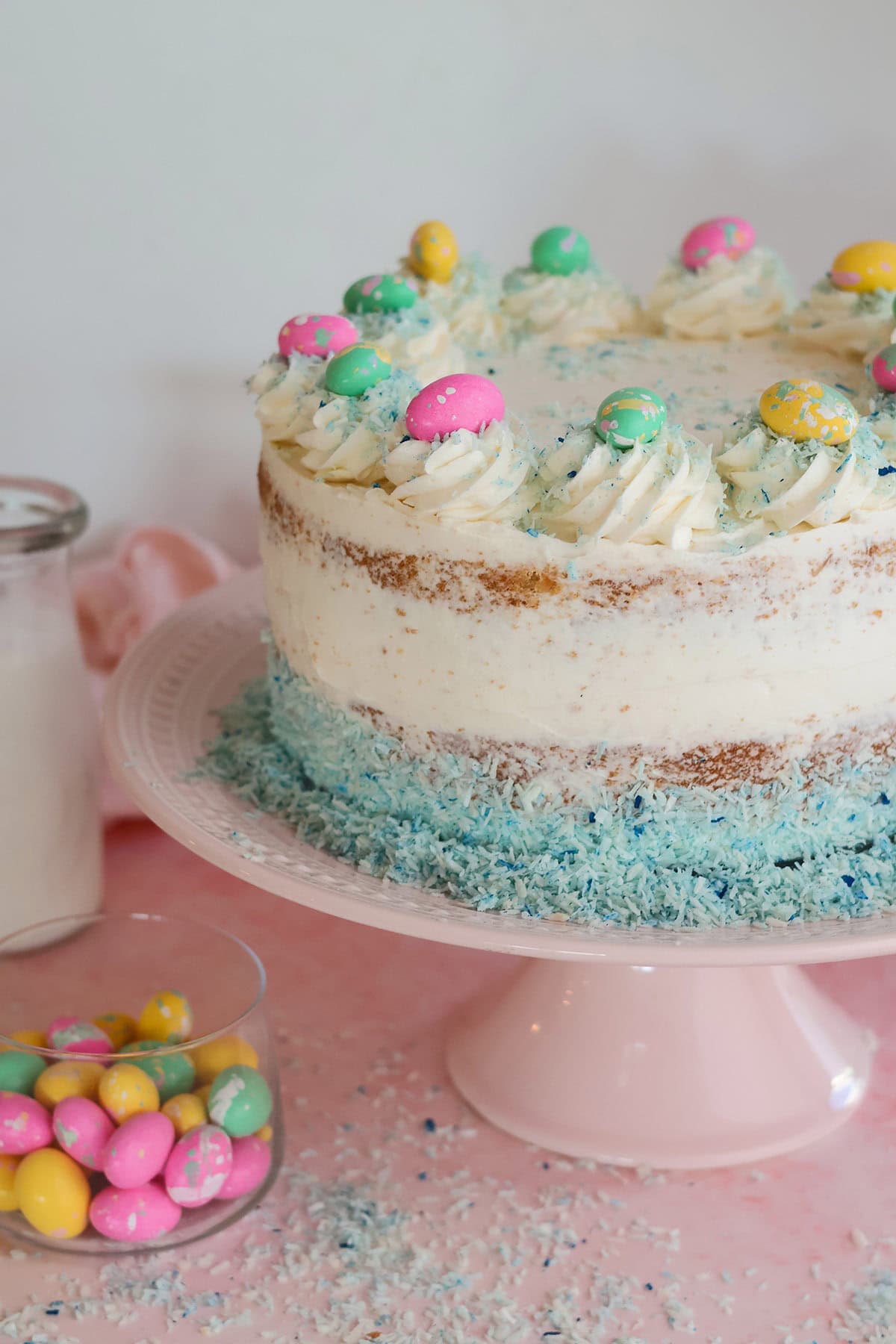 Frosted coconut cake on cake stand.