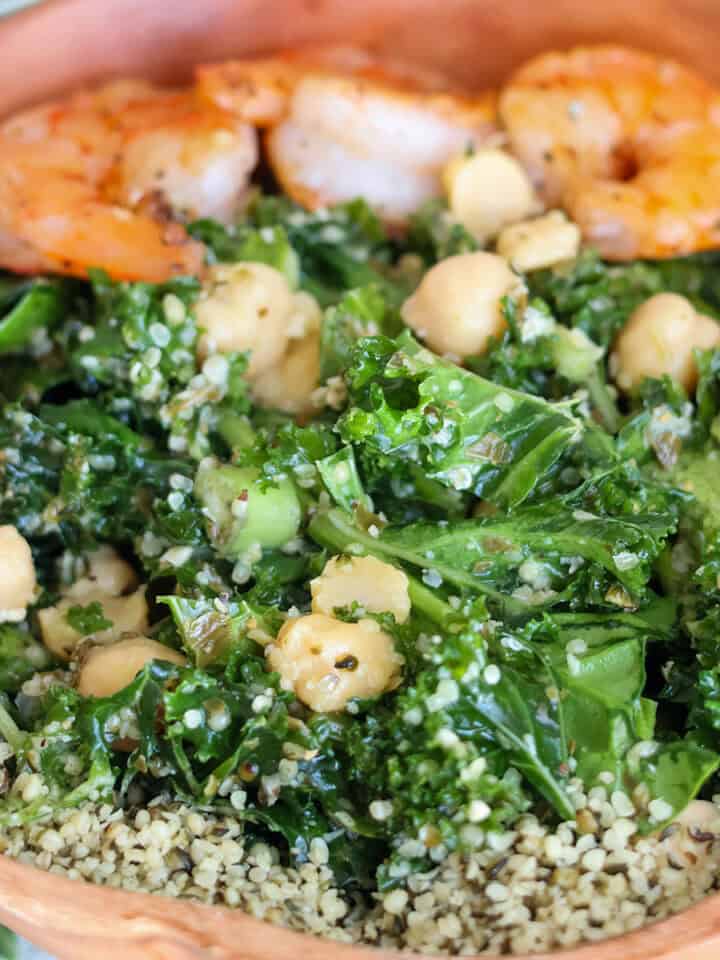 Bowlful of kale salad with hemp seeds and shrimp.