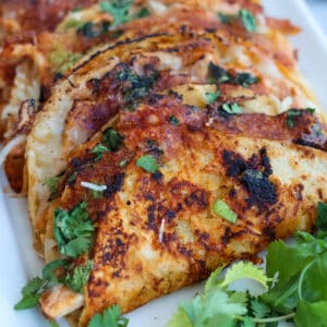 Plateful of crispy chicken tacos.