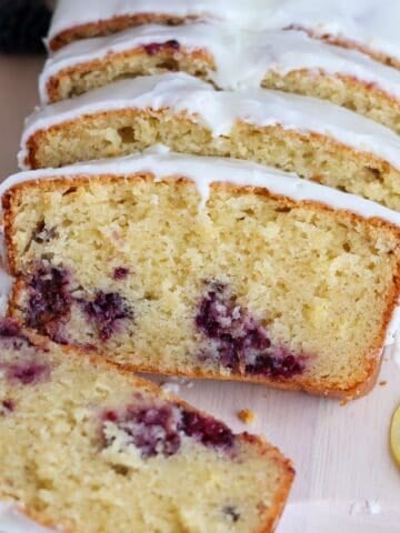 A blackberry lemon loaf cake sliced to show inside.