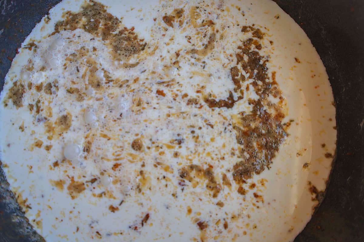 A skillet with creamy pasta sauce.