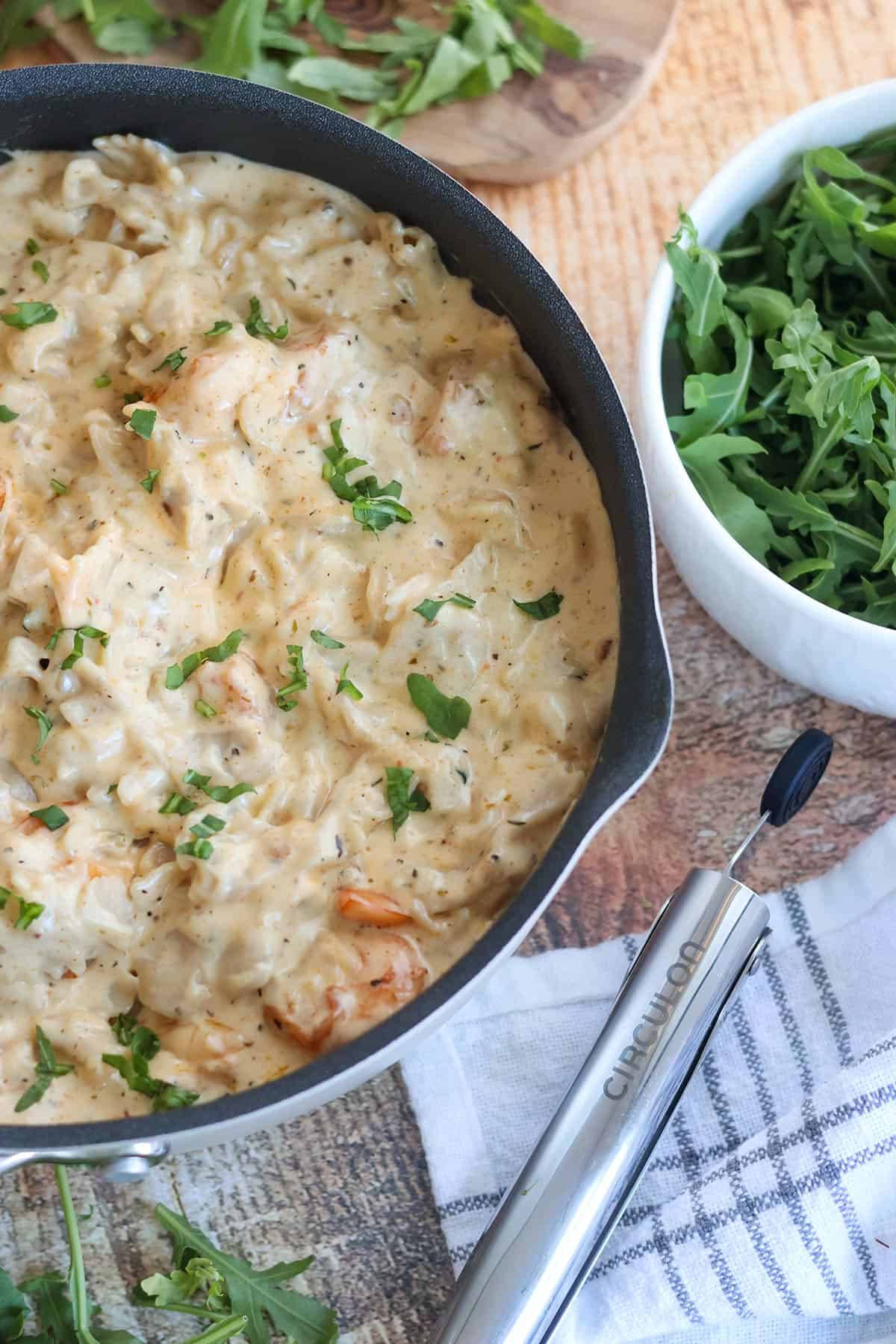 A skillet with creamy shrimp pasta. 