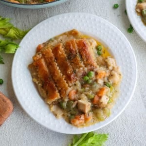 A white plate with chicken pot pie.