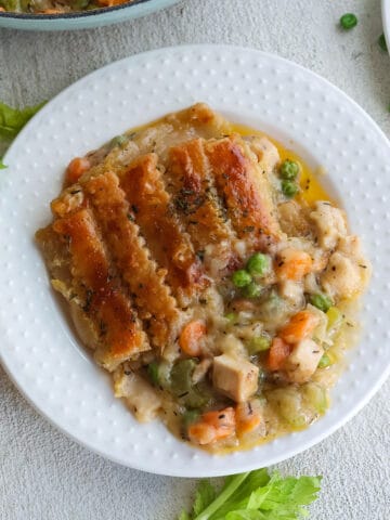 A white plate with chicken pot pie.