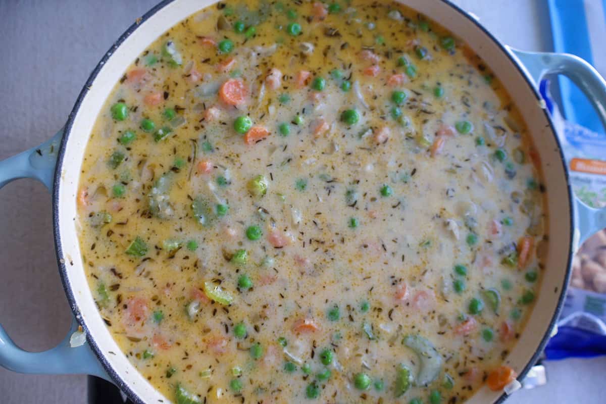 Creamy sauce with veggies in a skillet. 