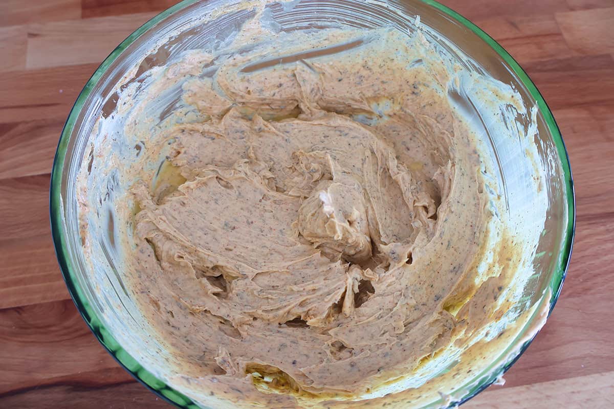 A glass bowl with herbed butter. 