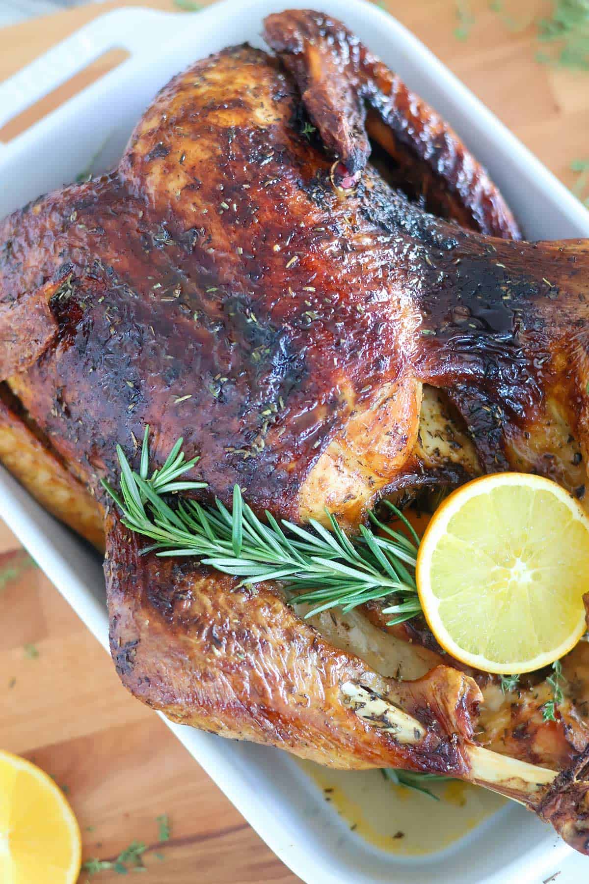 A whole roasted turkey on a whiteh baking dish