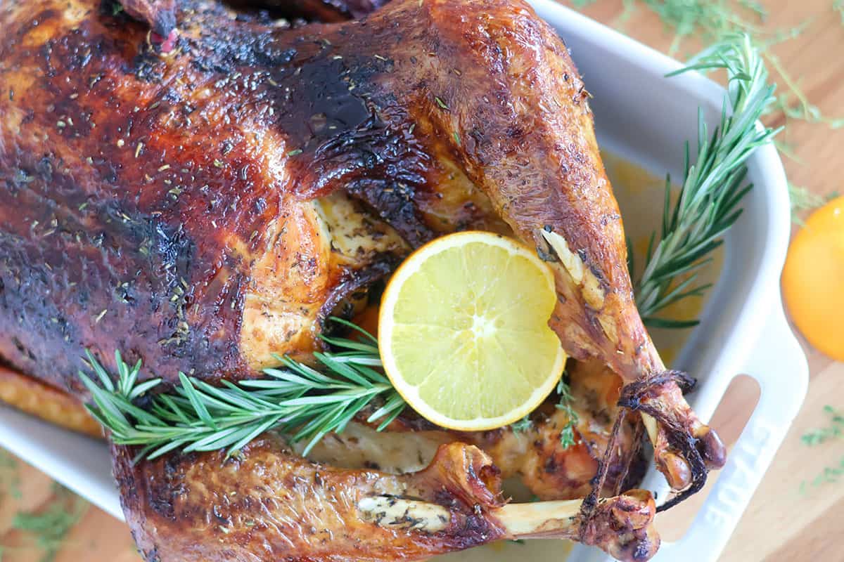 A roasted turkey in a white baking dish. 