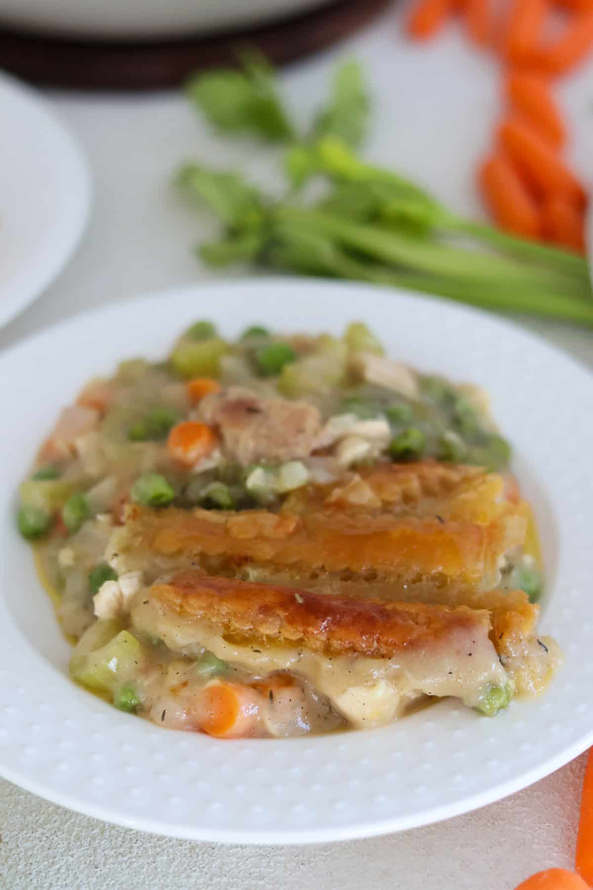 A white plate with a scoop of turkey pot pie. 