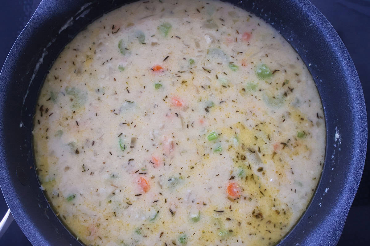A skillet full of veggies and creamy sauce.