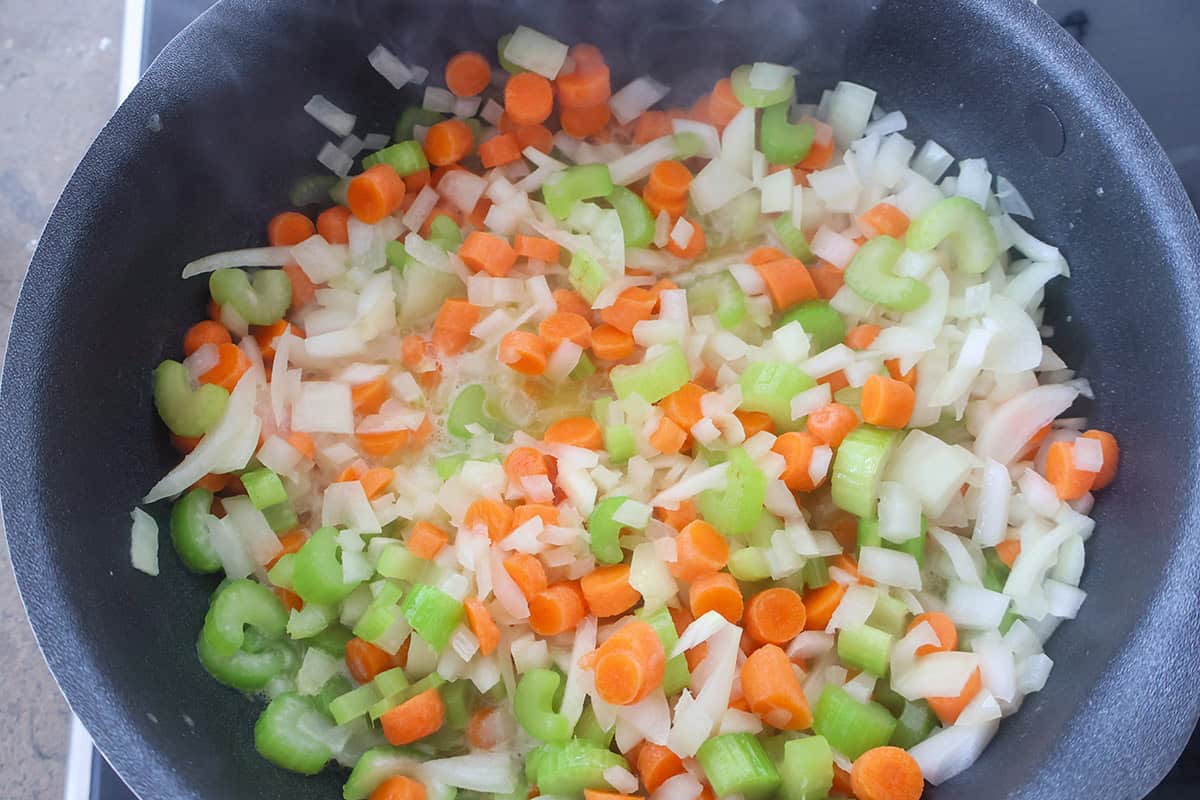 Sauteed carrots, celery, and onions in a skillet.