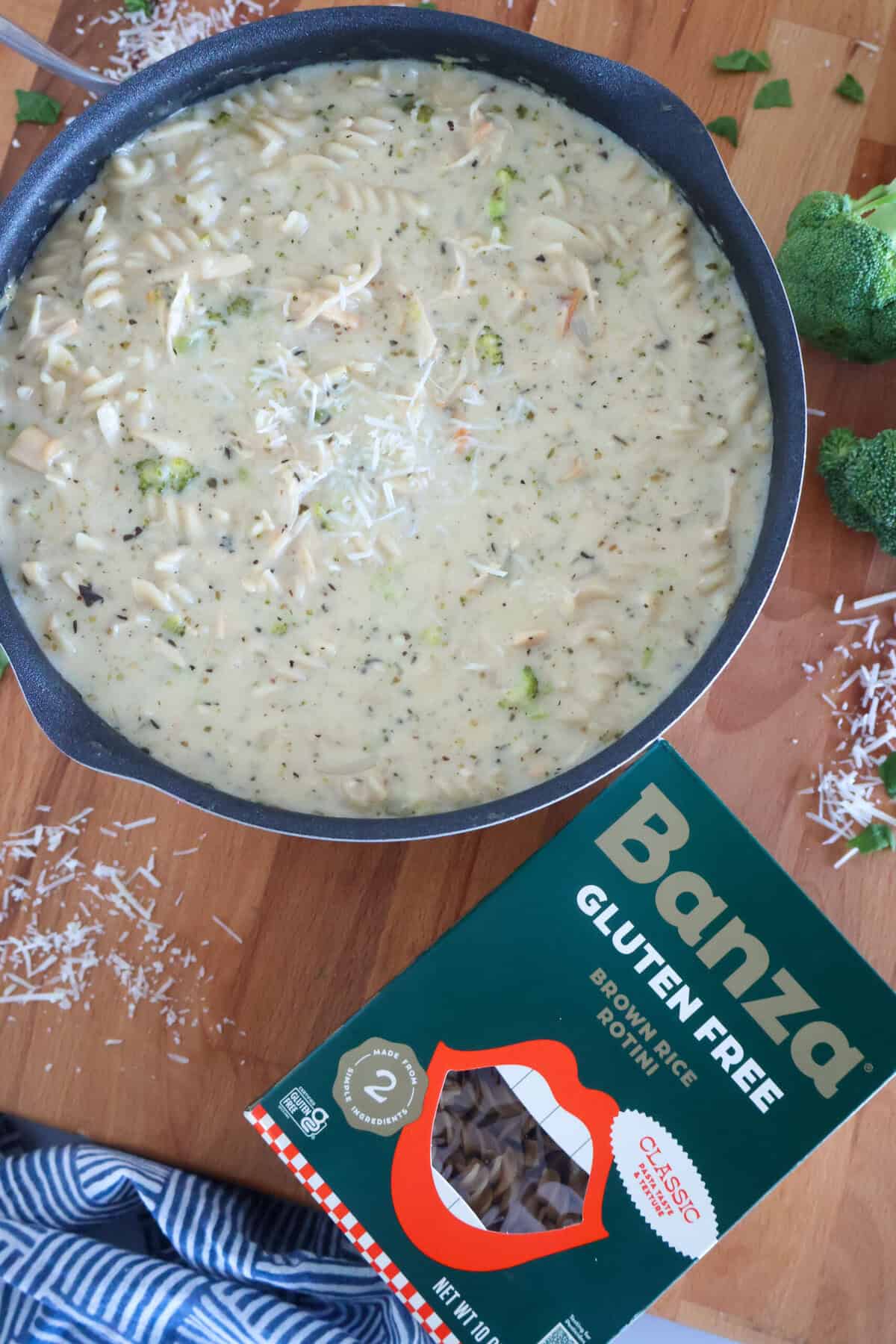 A big pot of chicken Alfredo soup with a box of Banza Brown Rice Rotini pasta next to it.