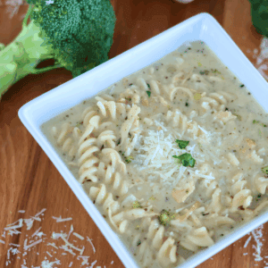 A bowl of Chicken Alfredo Soup with broccoli in the background.