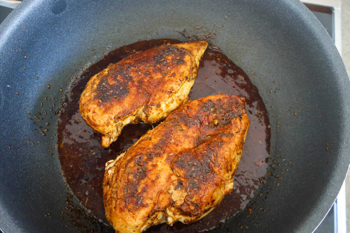 Chicken cooked in a black skillet.