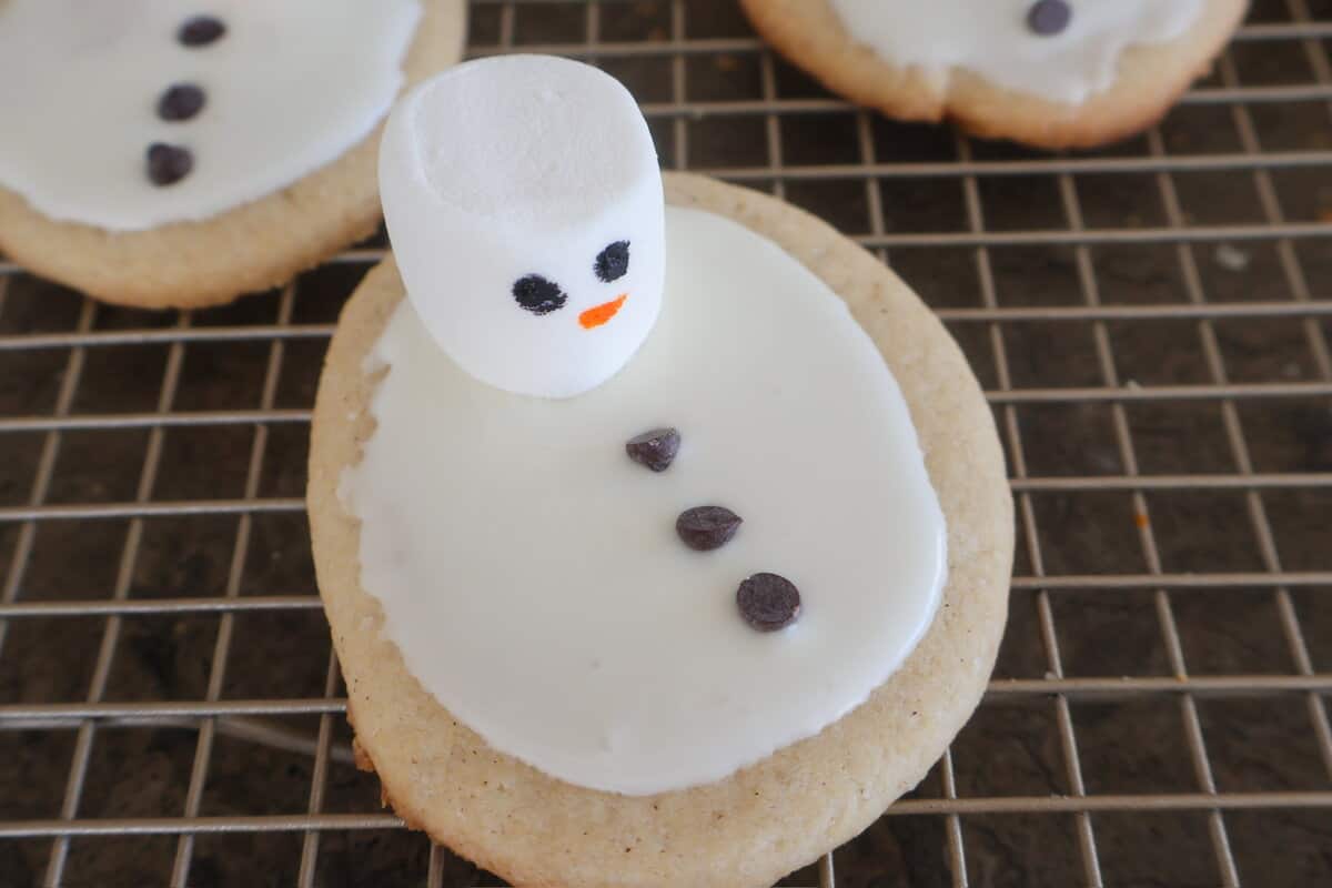 A Melted Snowman Cookie decorated and sitting on a cooling rack