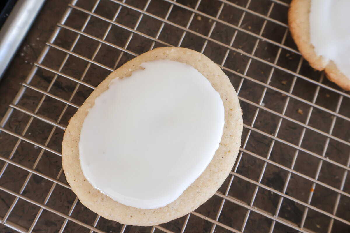 A frosted sugar cookie on a baking cooling rack