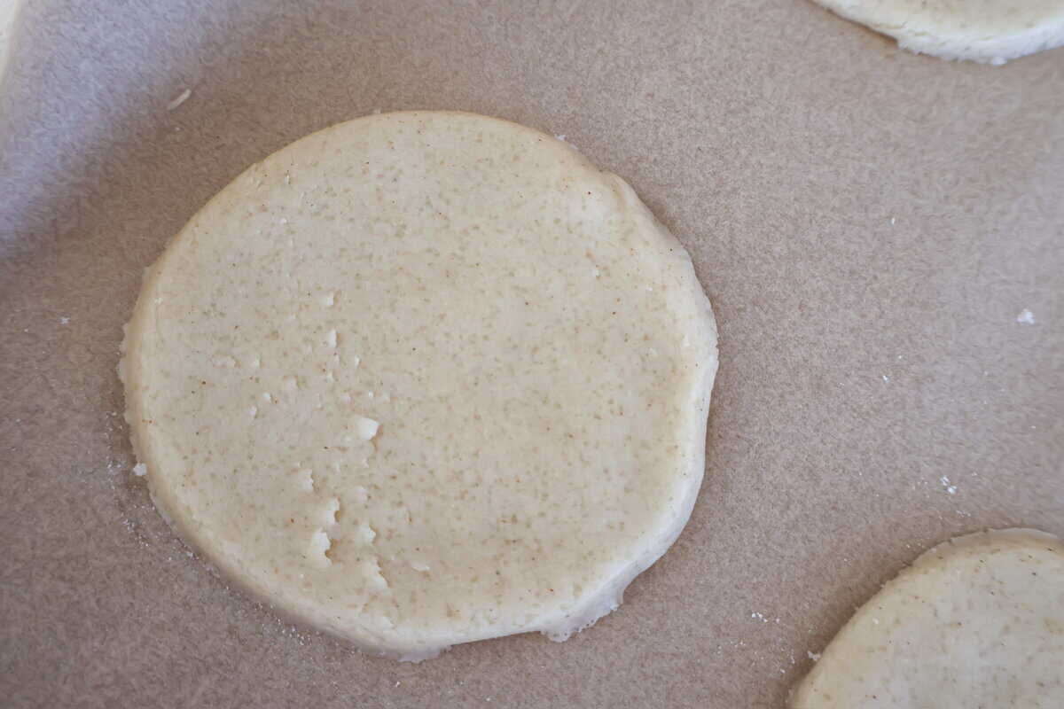 A raw sugar cookie on parchment paper.