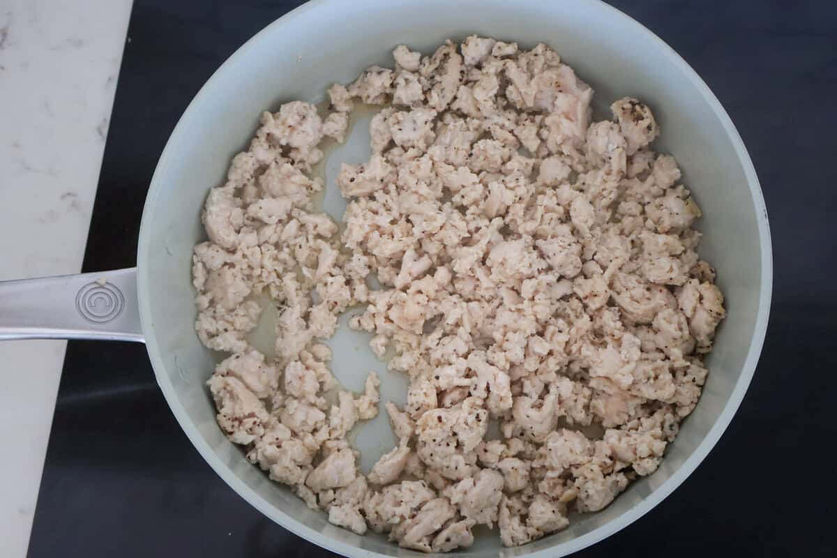 Browned ground chicken in a saute pan.