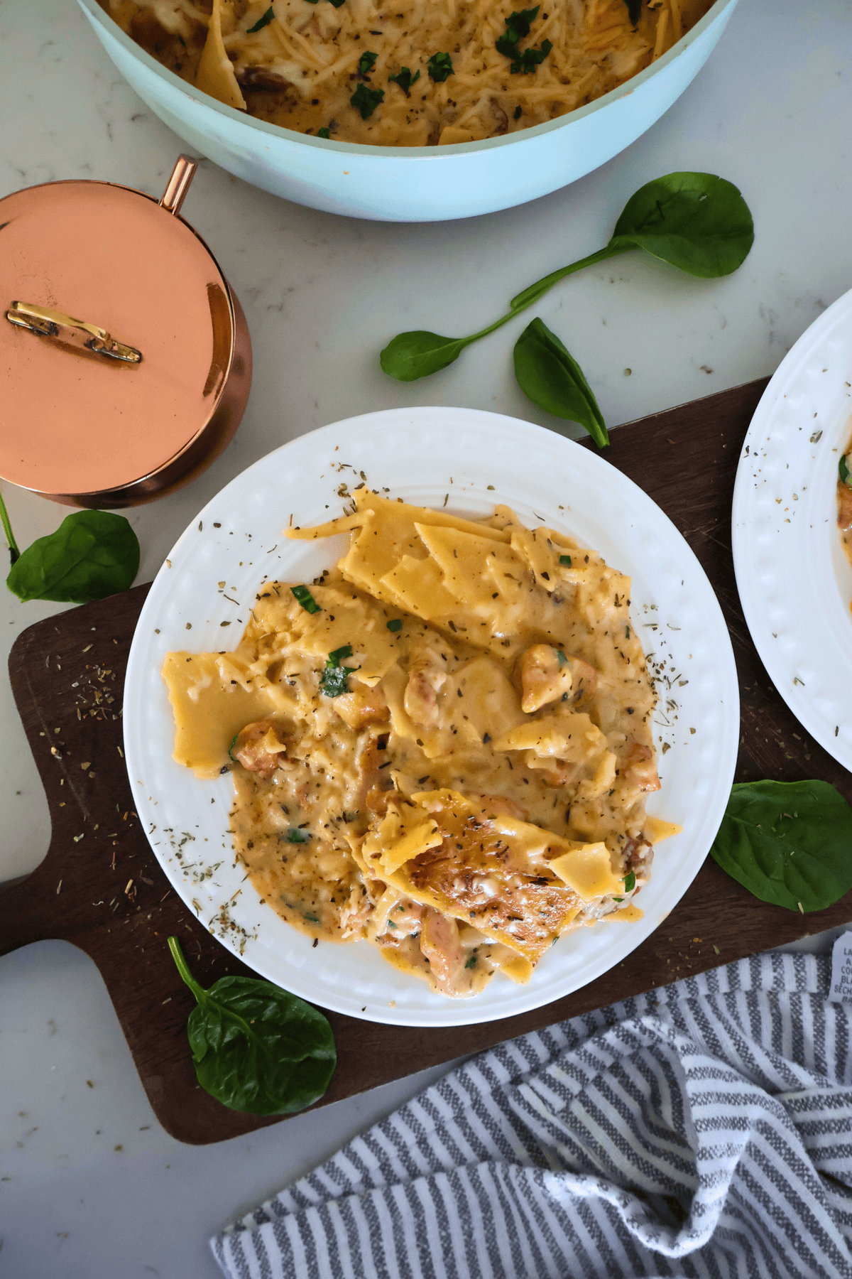 A plate of Gluten Free Chicken Alfredo on a cutting board with garnish.