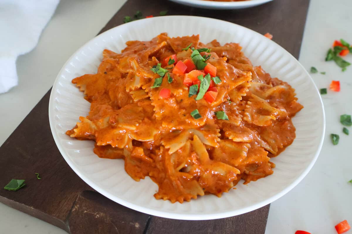 A white plate of Quick And Easy Chorizo Pasta with fresh garnish on top.