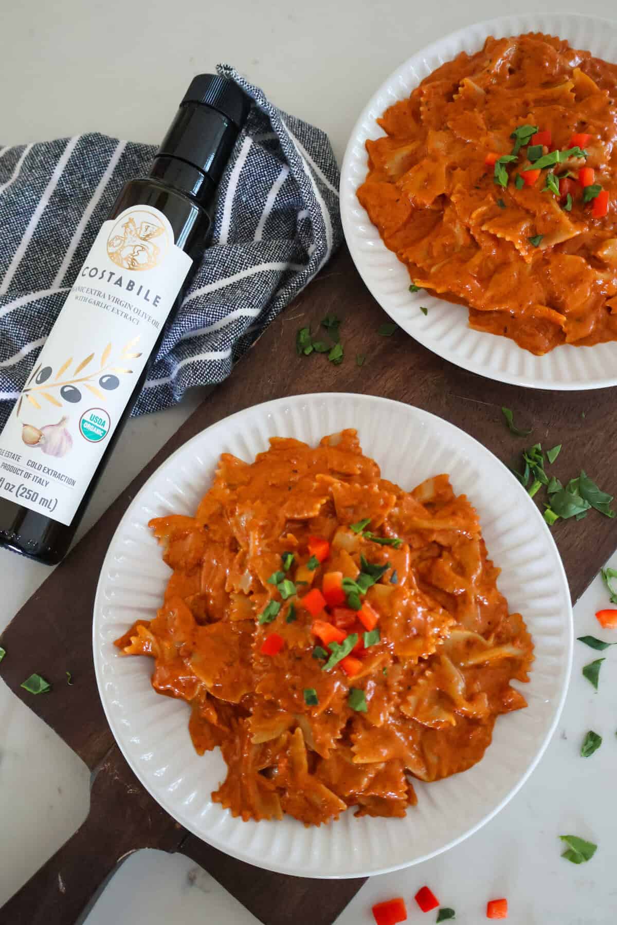 Two plates of Quick And Easy Chorizo Pasta on a cutting board.