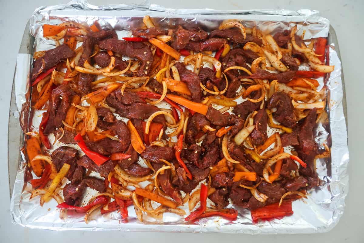 A sheet pan of raw steak Fajitas.