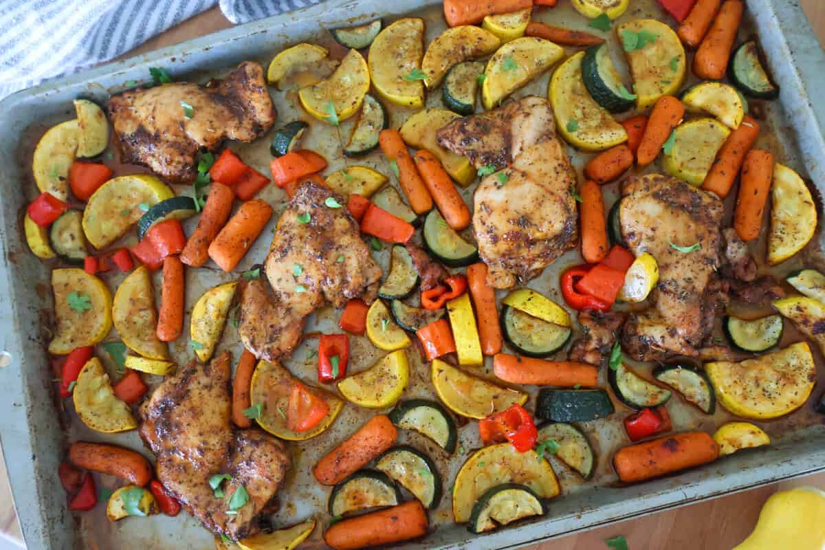 A sheet pan of cooked chicken and vegetables.