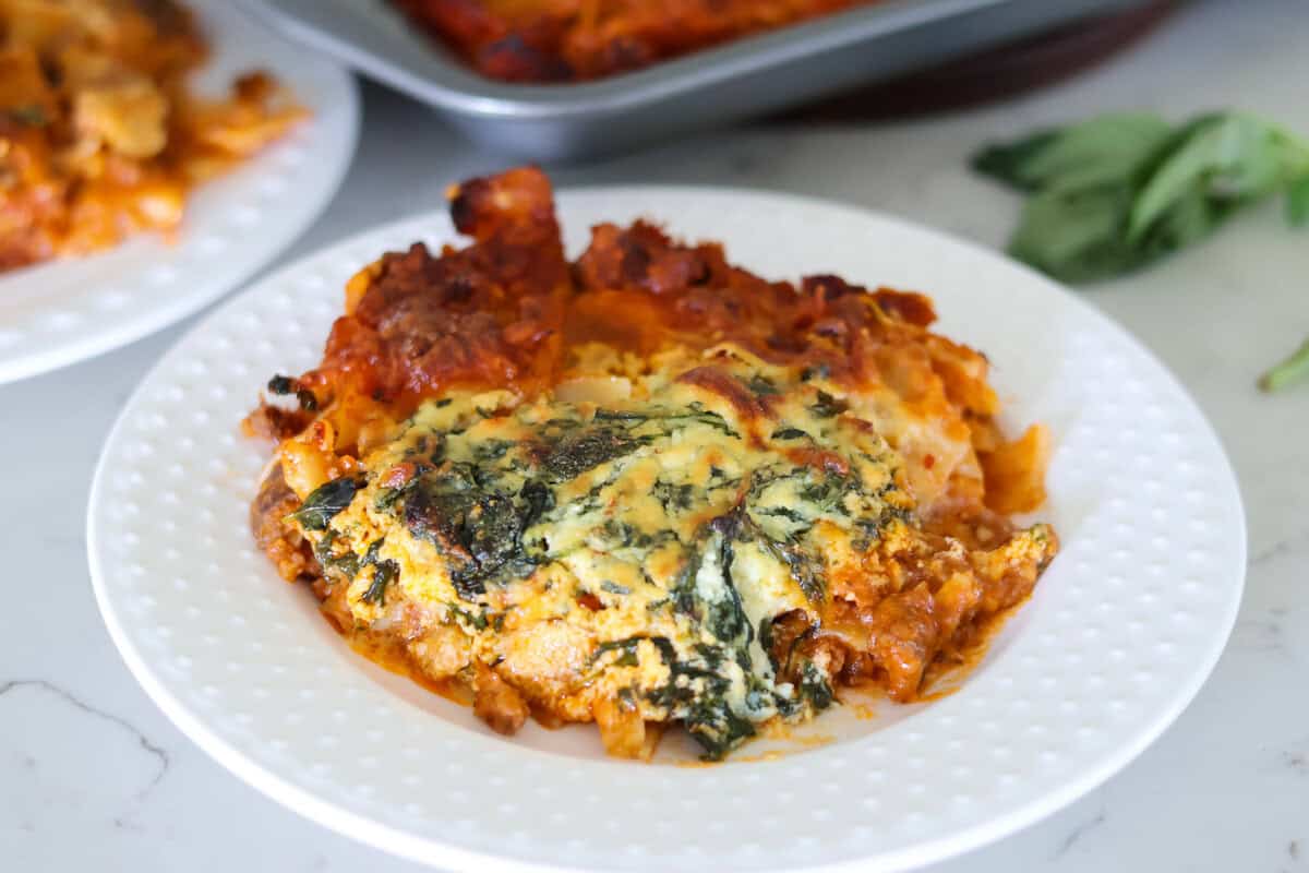 A white plate with a serving of sheet pan lasagna on top.