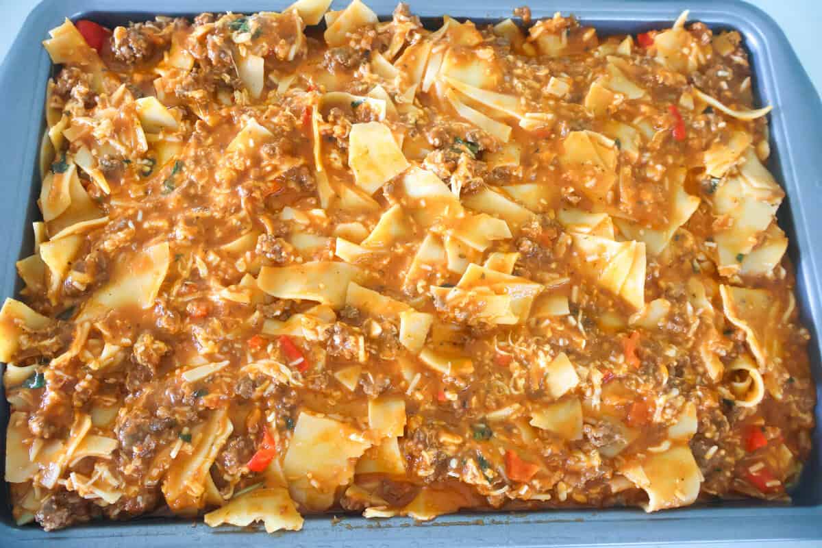 A sheet pan of lasagna about to be baked in the oven.