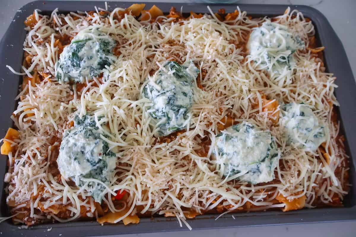 A sheet pan lasagna with ricotta and parmesan on top.