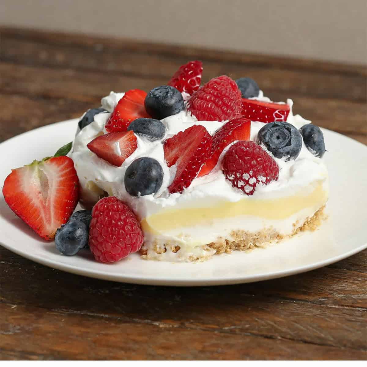 A slice of no-bake berry lush pie on a white plate.