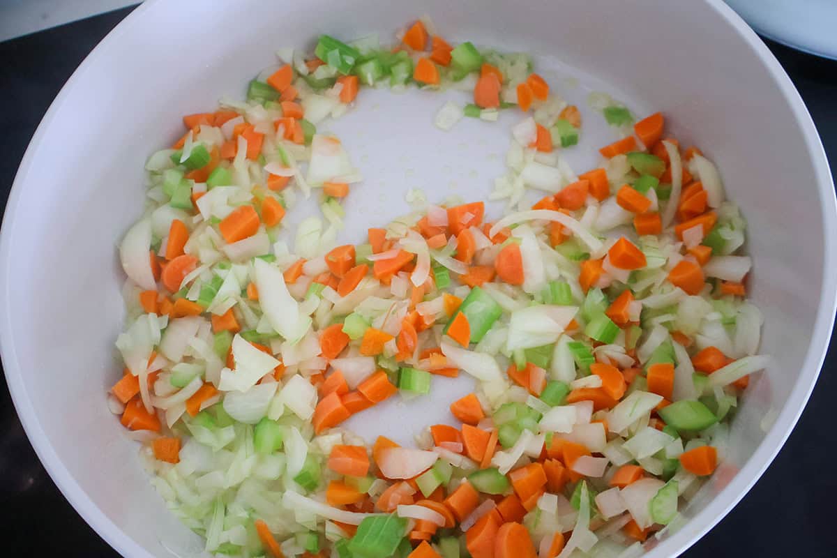 Sauted carrots, onions, and celery in a skillet.