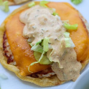 A Big Mac taco with cheese and Big Mac dressing on a white plate.