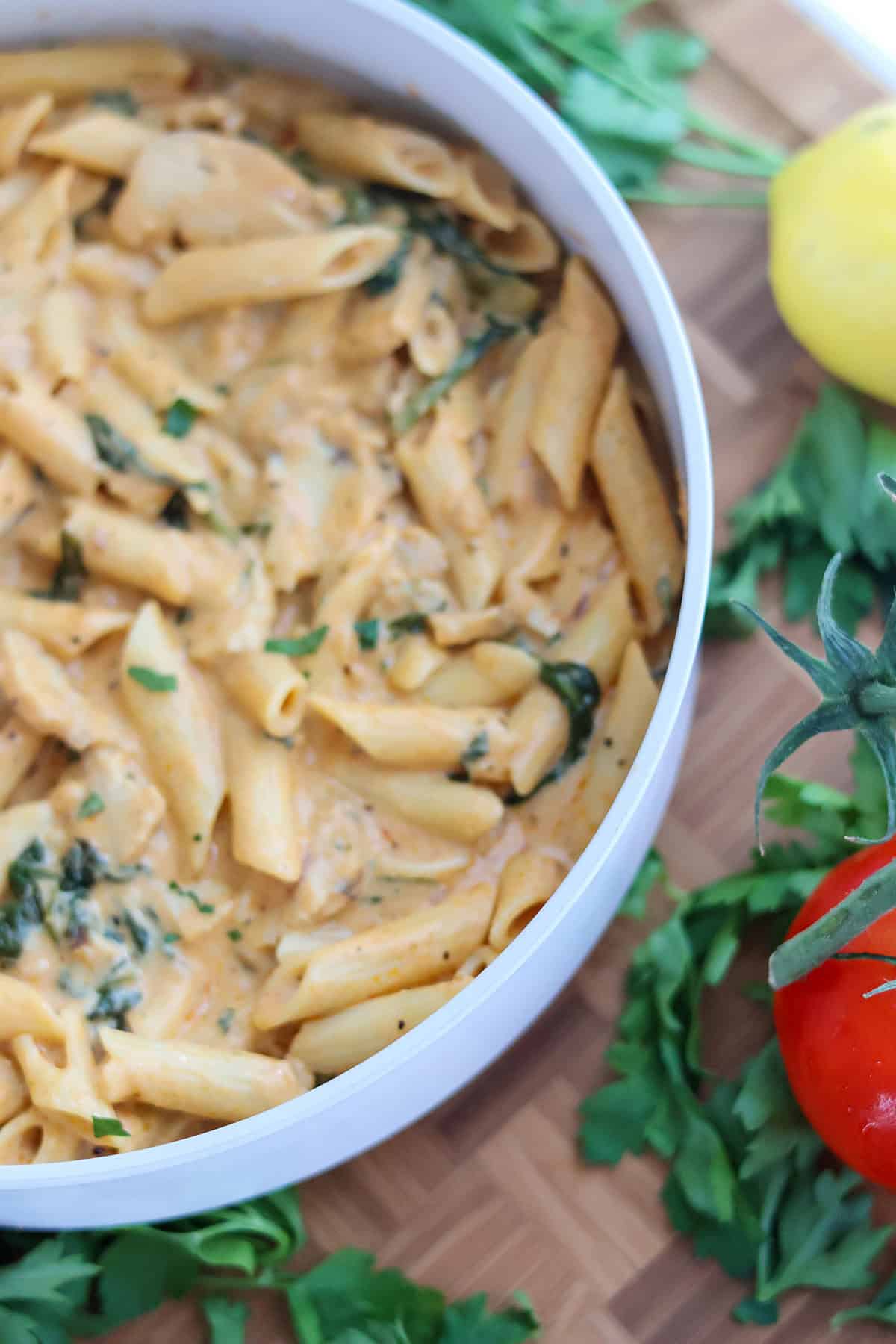 A white skillet filled with creamy chicken pasta.