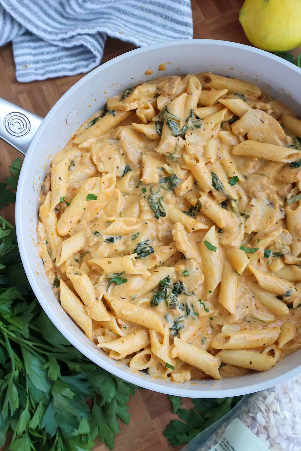 White skillet full of creamy chicken pasta. 